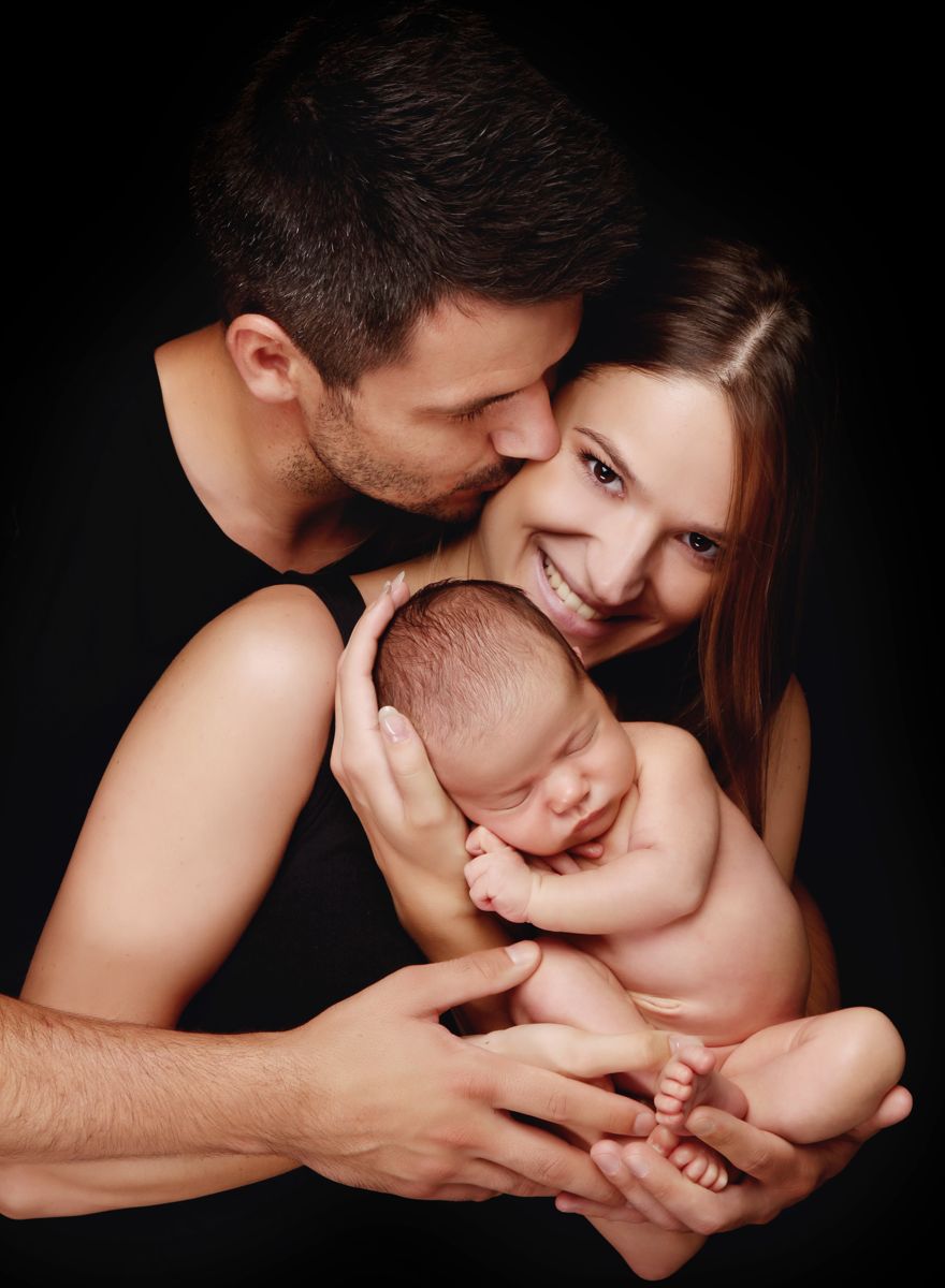Newborn focení s rodiči s miminkem v náručí a tatínkem líbajícím maminku