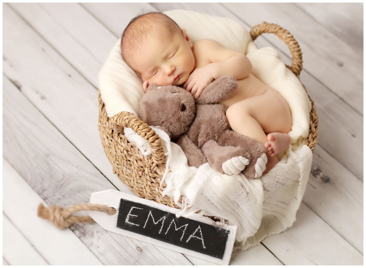 Roztomilé novorozeňátko spinkající v košíku s králíčkem