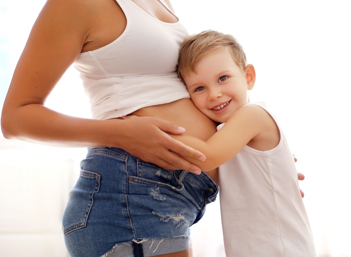 Přirozená fotka těhotného bříška se starším synem v ateliéru